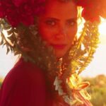 A guest in a red floral headpiece at sunset during Tessa's birthday celebration at Mandarin Oriental, Costa Navarino, filmed by Konstantinos Liopetas