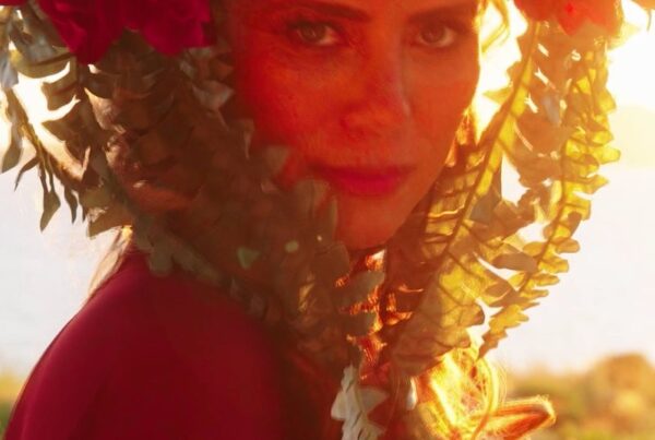 A guest in a red floral headpiece at sunset during Tessa's birthday celebration at Mandarin Oriental, Costa Navarino, filmed by Konstantinos Liopetas