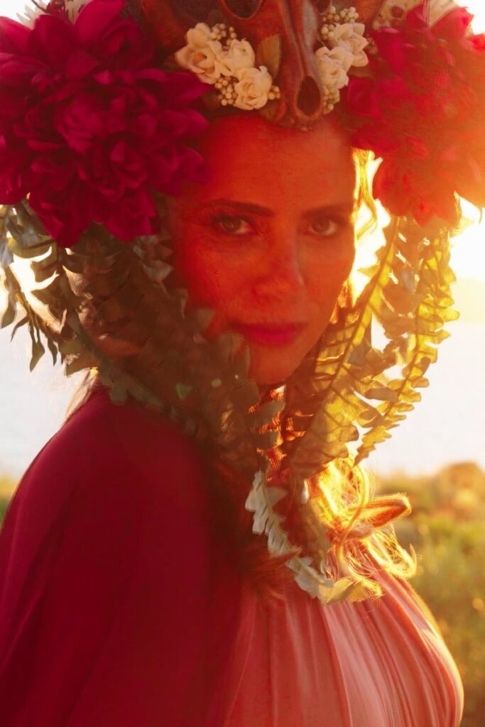 A guest in a red floral headpiece at sunset during Tessa's birthday celebration at Mandarin Oriental, Costa Navarino, filmed by Konstantinos Liopetas