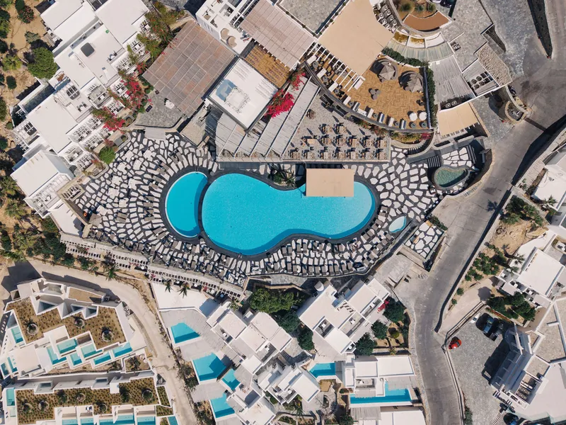 Aerial view of the Royal Myconian pool and whitewashed terraces on Mykonos