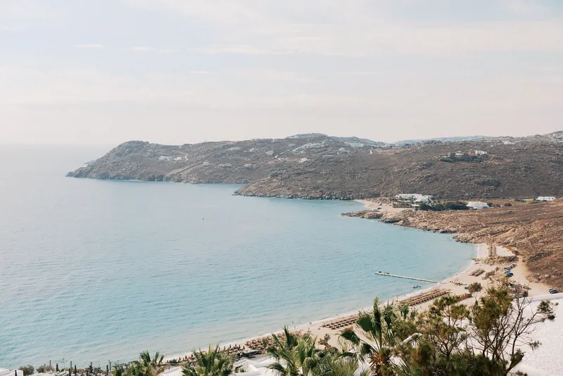 A sweeping Mykonos bay and beach in soft afternoon light